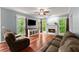 Inviting living room features a fireplace, ceiling fan, and large windows providing natural light at 1620 Bluewater Ct, Cumming, GA 30041