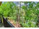 Balcony view of tall trees and a glimpse of the surrounding landscape at 28305 Plantation Ne Dr, Atlanta, GA 30324