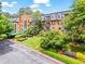 Stately brick apartment building with mature landscaping, manicured lawn, and convenient parking area at 28305 Plantation Ne Dr, Atlanta, GA 30324