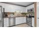 Well-lit kitchen with white cabinets, stainless steel appliances, and tile backsplash at 28305 Plantation Ne Dr, Atlanta, GA 30324