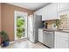 Bright kitchen featuring stainless steel appliances, white cabinets, and a window overlooking greenery at 28305 Plantation Ne Dr, Atlanta, GA 30324