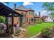 Large, manicured backyard with an outdoor kitchen and covered patio, attached to a large brick home at 31 Brownson Ct, Acworth, GA 30101