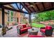 Covered patio in backyard view featuring stone fireplace, TV, comfortable seating and an outdoor built-in grill at 31 Brownson Ct, Acworth, GA 30101