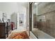 Bright bathroom with ceramic floors, a glass shower door, and antique cabinet with gray towels at 31 Brownson Ct, Acworth, GA 30101