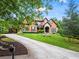 Elegant brick home with manicured lawn, a long driveway, and beautiful landscaping showcasing curb appeal at 31 Brownson Ct, Acworth, GA 30101