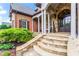 Elegant stone steps leading to a covered porch with stone pillars and a detailed front door with beautiful landscaping at 31 Brownson Ct, Acworth, GA 30101