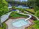 Aerial view of the community pool with a slide, surrounded by lush landscaping and tennis courts at 31 Brownson Ct, Acworth, GA 30101