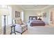 Cozy bedroom with a sitting area, a beautiful lamp, and plenty of natural light from windows with shutters at 5118 Greythorne Ln, Marietta, GA 30068
