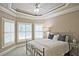 A well lit bedroom features a trey ceiling, ceiling fan, and windows with plantation shutters at 5118 Greythorne Ln, Marietta, GA 30068