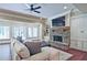 A living room features a stone fireplace, ceiling fan, wood floors, and a seating area at 5118 Greythorne Ln, Marietta, GA 30068