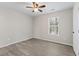 Bright bedroom features wood-look flooring, a ceiling fan, and a window for natural light at 6093 Camden Forrest Ct, Riverdale, GA 30296