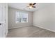Light-filled bedroom with ceiling fan, wood-look flooring, and large window at 6093 Camden Forrest Ct, Riverdale, GA 30296