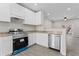 An updated kitchen with stainless steel appliances, white cabinets, granite countertops, and gray wood floors at 6093 Camden Forrest Ct, Riverdale, GA 30296