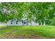 Charming home exterior with green lawn, partial view under trees at 6255 Saddlewood Dr, Lithonia, GA 30058