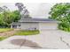 Home's exterior showcasing a two-car garage, attached house and driveway surrounded by lush trees at 6255 Saddlewood Dr, Lithonia, GA 30058