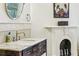 Bathroom vanity with marble counters, custom hardware, fireplace, and wall mirror at 185 Elizabeth St, Atlanta, GA 30307
