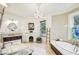 Bright bathroom featuring a chandelier, corner tub, vanity, and marble floors at 185 Elizabeth St, Atlanta, GA 30307