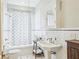 Well-lit bathroom featuring a classic pedestal sink and a shower-tub combo with elegant white tiling at 185 Elizabeth St, Atlanta, GA 30307