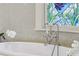 Close up on bright bathtub with stainless steel hardware and mosaic tile details at 185 Elizabeth St, Atlanta, GA 30307