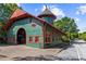 Unique train depot with striking architecture, features red trim and green siding, set amongst lush greenery at 185 Elizabeth St, Atlanta, GA 30307