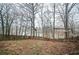 View of tree-lined backyard with a fence and a swing set overlooking the nearby lake at 4157 Lake Mist Nw Dr, Kennesaw, GA 30144