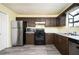 Spacious kitchen featuring stainless steel appliances, dark cabinets, gray flooring and ample counter space at 4157 Lake Mist Nw Dr, Kennesaw, GA 30144
