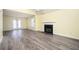 Bright living room with new gray flooring, a ceiling fan, a fireplace, and adjacent dining area at 4157 Lake Mist Nw Dr, Kennesaw, GA 30144