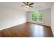 Spacious bedroom with a tray ceiling, hardwood floors, a ceiling fan, and large windows at 541 Mckenzie Ave, Stockbridge, GA 30281