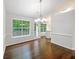 Bright dining area featuring a modern chandelier, rich hardwood floors, and natural light from the windows at 541 Mckenzie Ave, Stockbridge, GA 30281