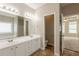 Well-lit bathroom featuring double sinks and a view into the main bedroom at 6053 Park Close, Fairburn, GA 30213