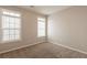 Bright bedroom with plush carpeting, two windows and light beige paint at 6053 Park Close, Fairburn, GA 30213