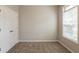 A cozy bedroom features plush carpeting, neutral walls, and a window for natural light at 6053 Park Close, Fairburn, GA 30213