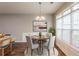Bright dining area with wood floors, modern chandelier, and large windows allowing ample natural light at 6053 Park Close, Fairburn, GA 30213