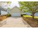 Two car garage with concrete driveway surrounded by lush landscaping at 6053 Park Close, Fairburn, GA 30213