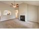 Open-concept living room with fireplace, view to the kitchen, and ceiling fan at 6053 Park Close, Fairburn, GA 30213