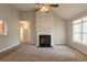 Comfortable living room showcasing a fireplace, a ceiling fan, and access to an adjacent hallway at 6053 Park Close, Fairburn, GA 30213