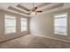 Large main bedroom with tray ceilings, ample windows, and plush carpeting at 6053 Park Close, Fairburn, GA 30213