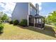 Spacious backyard with green grass and covered patio next to blue-sided house at 2341 Lily Valley Dr, Lawrenceville, GA 30045
