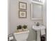 Charming powder room with pedestal sink, seashell prints, and a decorative mirror at 2341 Lily Valley Dr, Lawrenceville, GA 30045