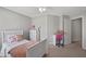 Well-lit bedroom with neutral carpet features a white bed frame and furniture with desk and rolling chair at 2341 Lily Valley Dr, Lawrenceville, GA 30045