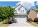 Charming two-story home featuring blue siding, stone accents, an attached garage, and a well-manicured front yard at 2341 Lily Valley Dr, Lawrenceville, GA 30045