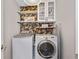Well-organized laundry room features a washer, dryer, storage cabinets, and stylish wallpaper at 2341 Lily Valley Dr, Lawrenceville, GA 30045