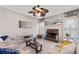 Bright living room features a stone fireplace, stylish ceiling fan, and neutral decor at 2341 Lily Valley Dr, Lawrenceville, GA 30045