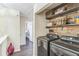 Convenient laundry room featuring updated appliances and attractive wood shelving for storage at 285 Enterprise Path, Hiram, GA 30141
