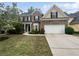 Charming two-story brick home featuring a manicured lawn, attached garage, and a welcoming entrance at 403 Vinings Vintage Cir, Mableton, GA 30126