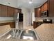 Well-lit kitchen featuring stainless steel appliances, granite countertops and brown cabinets at 403 Vinings Vintage Cir, Mableton, GA 30126