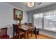 Inviting dining room featuring a wood table, four chairs, light fixture and natural light from a window at 6118 Queen Anne Ct, Norcross, GA 30093