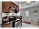 Well-lit kitchen showcases dark wood cabinets, black countertops, stainless steel range, and a convenient eat-in dining area at 6118 Queen Anne Ct, Norcross, GA 30093
