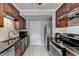 Kitchen with dark wood cabinetry, stainless steel appliances, and sleek black countertop at 6118 Queen Anne Ct, Norcross, GA 30093