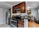 Bright kitchen with stainless steel appliances, including a refrigerator and range, alongside dark wood cabinets and black countertops at 6118 Queen Anne Ct, Norcross, GA 30093
